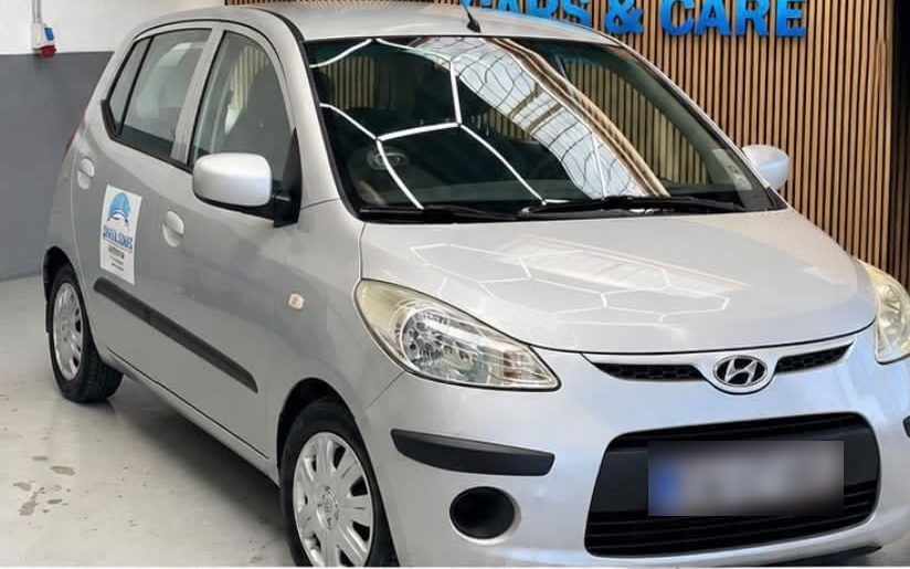 Sølvfarvet Hyundai i10 set skråt forfra, hos Cars & Care i Slagelse